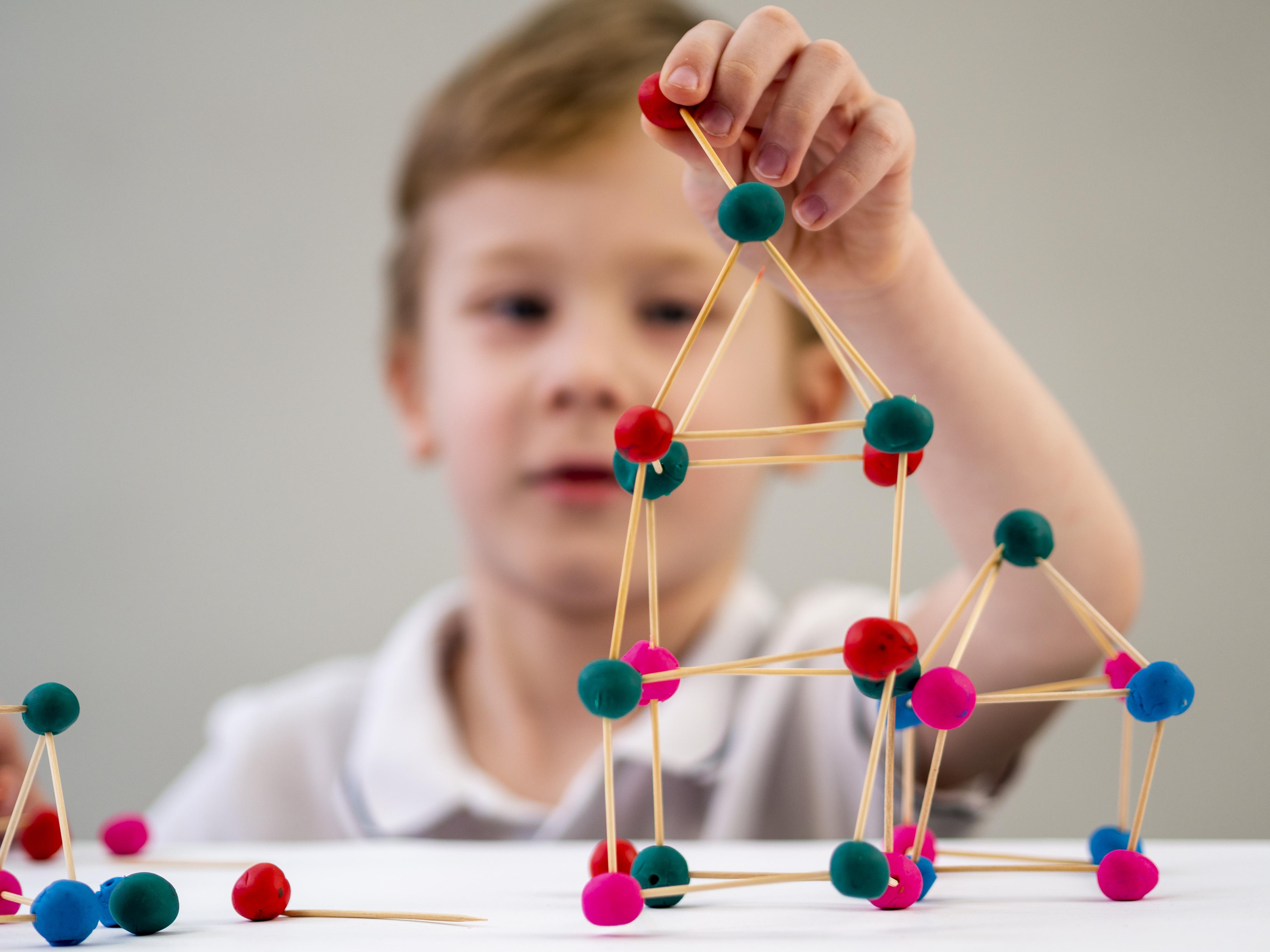 boy-playing-with-colorful-atoms-game-table