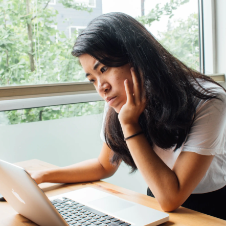A woman looking at a laptop 